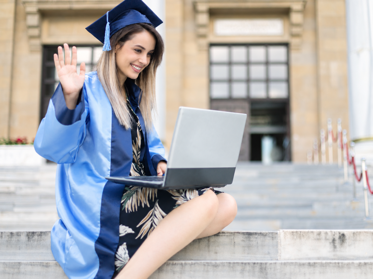 Une diplômée en tenue de cérémonie utilisant un ordinateur portable